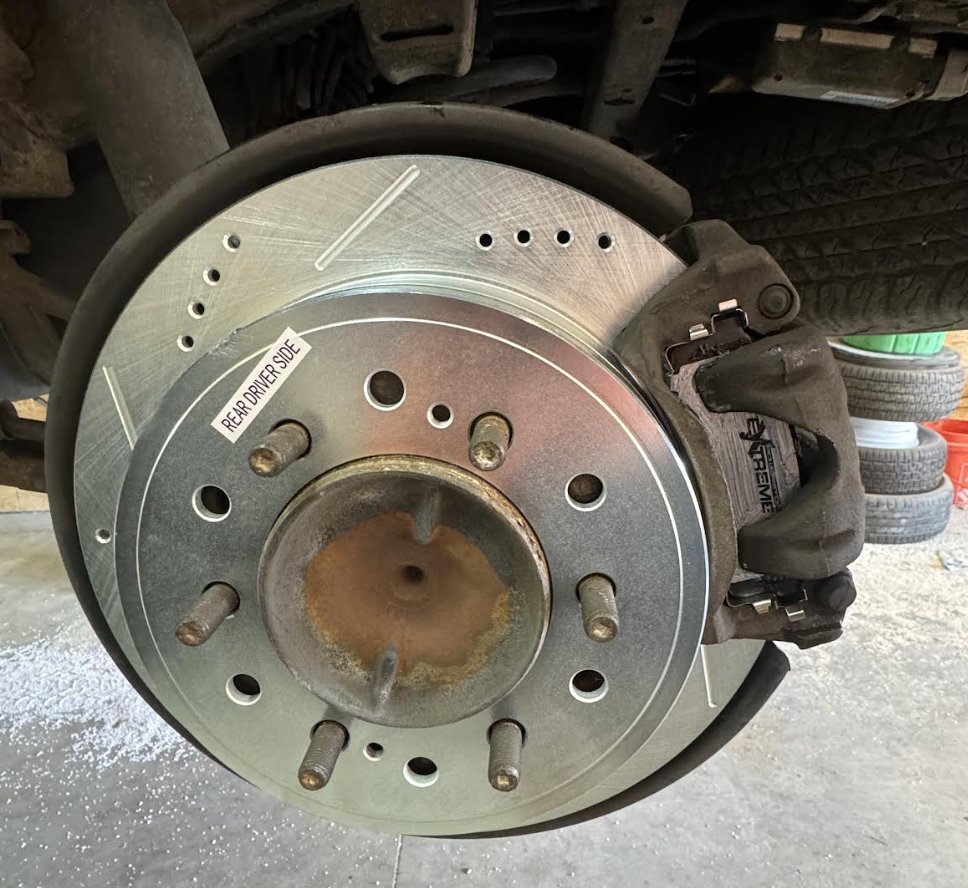 Drilled and slotted brake rotor with a PowerStop caliper fitted to a rear hub